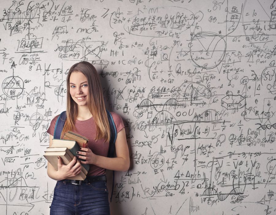 Happy student holding books with math equations